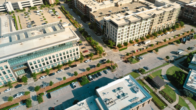 Tree lined street busy parked cars in mixed-use development Cypress Waters, Dallas, corporate office buildings, commercial zones, sustainable land use modern infrastructure in dense metropolitan