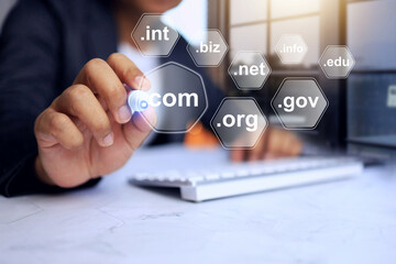 Domain name concept with businessman pointing a pen to selected .com to be a top level of domain in...