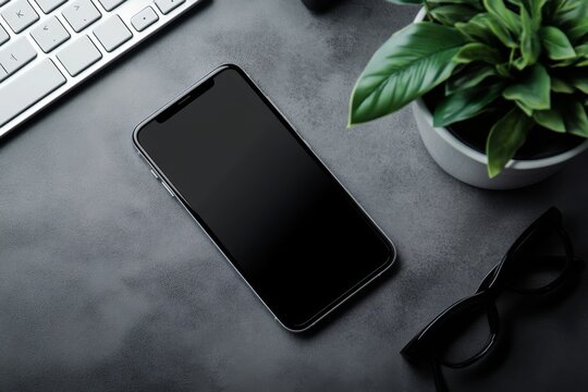 A smartphone rests on a textured surface beside a keyboard and a potted plant, creating a modern workspace aesthetic.
