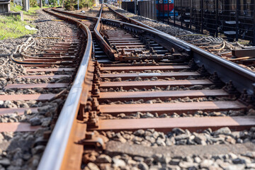 Close-up of railway tracks and switch system with metal rails and wooden sleepers forming a...
