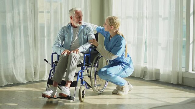 Help support retirement healthcare. Nurse helping old man in wheelchair. Patient and woman in nursing home for medical caregiver. Nurse taking care of paralyzed man in chair for people with disability