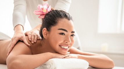 Relaxing Massage. Young asian woman getting classical body treatment at spa salon, lying on...