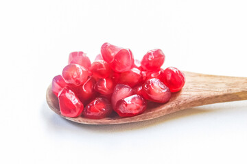 spoon full of pomegranate seeds isolated on white background