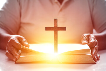 Hands woman with bible praying. Christian wooden cross on open bible, Holy concept