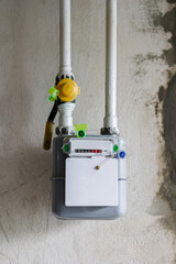 Vertical photo of gas meter and pipes, on concrete wall in a house under renewal. Indoor gas meter used for measuring natural gas consumption in residential buildings, houses. Energy crisis in Europe