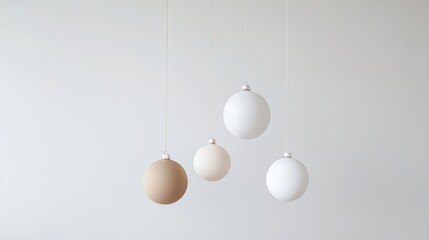 Minimalist Christmas composition with four neutral-toned ornaments suspended against a soft white background. A clean, modern holiday design perfect for elegant seasonal themes and mockups.