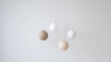 Minimalist Christmas composition with four neutral-toned ornaments suspended against a soft white background. A clean, modern holiday design perfect for elegant seasonal themes and mockups.