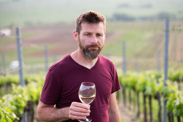 happy man tasting wine in a vineyard
