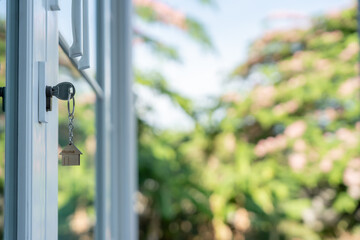 key for unlocking house is plugged into the door. Second hand house for rent and sale. keychain is blowing in the wind. mortgage for new home, buy, sell, renovate, investment, owner, estate