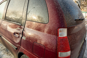 The red car suffered damage to the rear door as a result of a road accident. There is a dent on the door indicating a strong impact.
