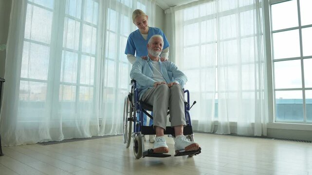 Help support retirement healthcare. Nurse helping old man in wheelchair. Patient and woman in nursing home for medical caregiver. Nurse taking care of paralyzed man in chair for people with disability