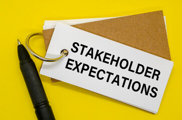 Small notebook labeled STAKEHOLDER EXPECTATIONS with clip on white background