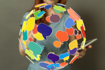 Stock photo of a woman holding a sphere of colorful speech bubbles, symbolizing communication and...