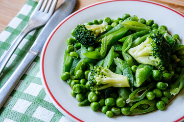 A Plate Of Fresh Cooked Vegetables Including, Peas, Runner Beans And Broccoli