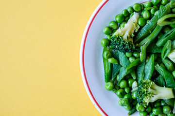A Plate Of Fresh Cooked Vegetables Including, Peas, Runner Beans And Broccoli