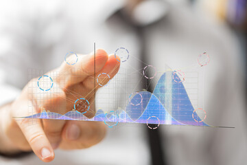 Person interacts with a holographic chart displaying business growth data and key performance...