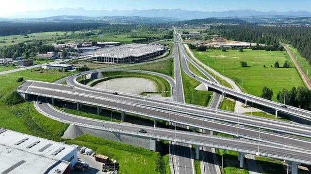 End of new Zakopianaka highway in Nowy Targ, Poland. Interchange with old road from Krakow to Zakopane. State in 2025. Far foggy view of Tatra mountains. Aerial 4K video. Time lapse. Speed x 4