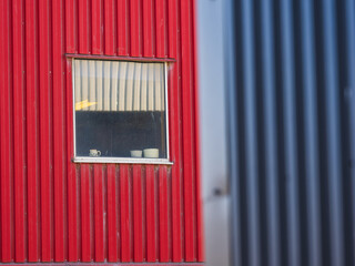 Worn out industrial building with distinctive red and gray metal siding in Falkenberg, Sweden, showcasing a unique cityscape detail