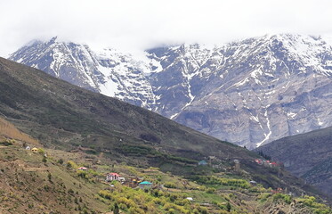 Fototapeta premium beautiful remote mountain village of lahaul valley, scenic view of snowcapped peak of himalayas, lahaul and spiti in himachal pradesh in india