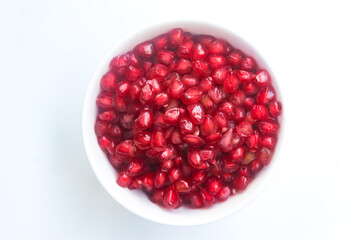 pomegranate seeds in a glass bowl isolated