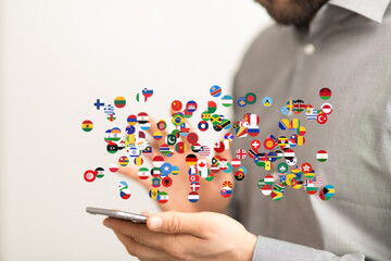 A person interacts with a smartphone displaying numerous world flags, symbolizing global connectivity and international communication.