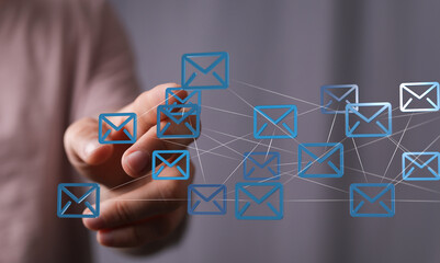 Hand interacting with a network of email icons, representing global communication and connectivity.