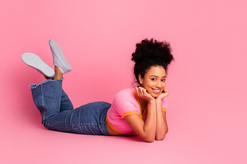 Young woman in casual stylish outfit smiling happily while posing on a pink background, radiating...