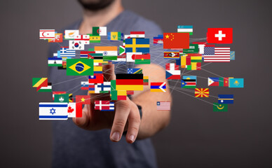 Man interacts with a digital network of flags representing global connectivity and international...