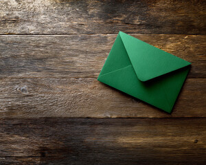 A vibrant green envelope rests elegantly on a rustic wooden surface, showcasing a blend of color and texture, perfect for creative invitations or heartfelt letters.