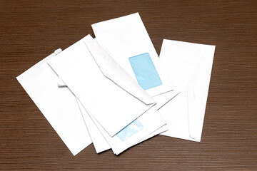 Large pile of blank open white paper envelops on a wood table