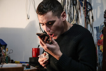 A master technician performing screen gluing on a phone, using specialized electronics tools and wipes. Expert screen gluing in action