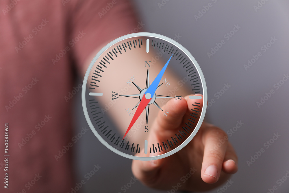 Poster Close-up of hand interacting with a digital compass, showing navigation and direction finding.