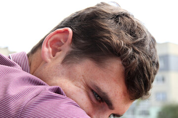 Close-up portrait of a man with striking curly brown hair and distinctive freckles on his face. A detailed portrait focusing on a man face, highlighting his curly brown hair and natural freckles