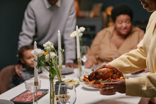Black family savoring a Thanksgiving dinner with roast turkey centerpiece, arranged with elegant table settings - Powered by Adobe