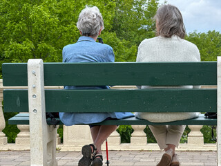 Couple de personnes âgées assis sur un banc dans le parc, vue arrière