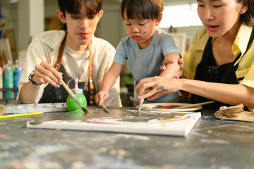 Cropped image of a toddler participating in painting class with parent, Early Learning Through Art