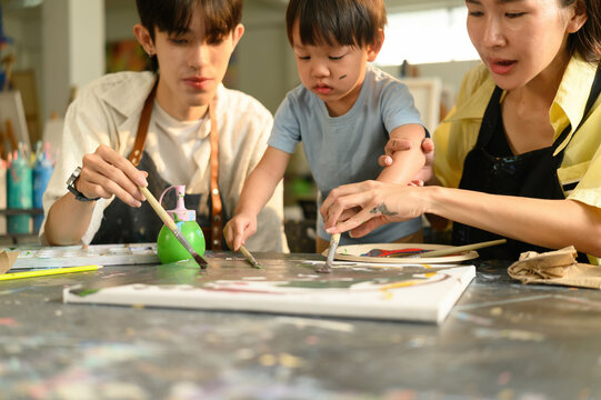 Cropped image of a toddler participating in painting class with parent, Early Learning Through Art - Powered by Adobe