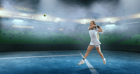 Woman tennis player playing tennis on professional tennis stadium in night.