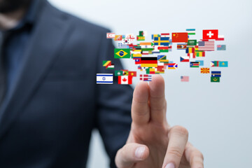 Image of a businessman interacting with a digital display of world flags, symbolizing global reach...