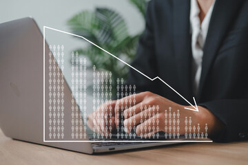 Businessperson working on laptop with a decreasing trend graph representing employment statistics or economic downturn.