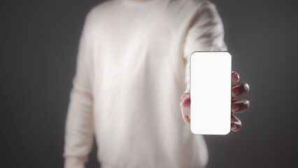 A person presents a smartphone with a pristine blank white screen, offering a versatile template for app showcases, digital content displays, or contemporary mobile technology concepts.