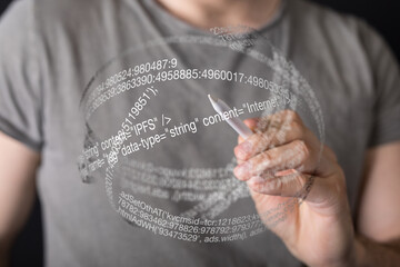A person uses a stylus to write code on a futuristic transparent screen.  Modern technology concept.