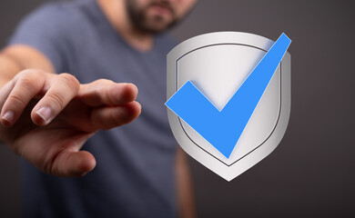 Image of a hand reaching for a digital shield with a checkmark, symbolizing data protection and...