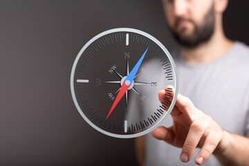 A man uses a digital compass to find his way.  Concept of navigation, direction, and guidance.