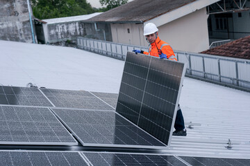 Engineer installing solar panels on wet metal rooftop during cloudy weather