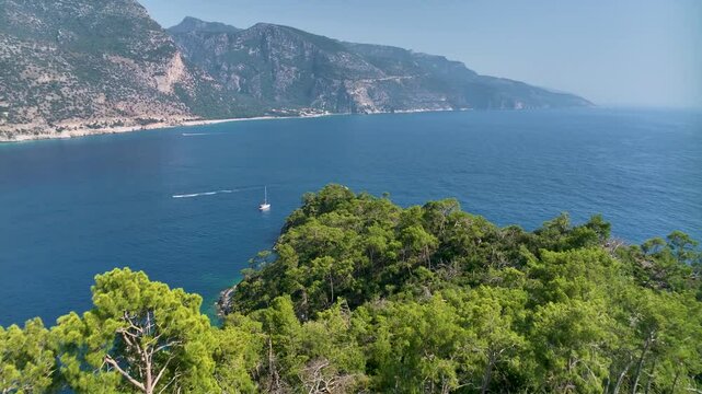Wonderful aerial view of a gulet entering the amazing oludeniz lagoon, fethiye, turkey, with its turquoise waters and white sand beach surrounded by green lush vegetation