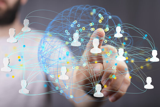 Image of a hand interacting with a digital network of connected people, representing global communication and teamwork.