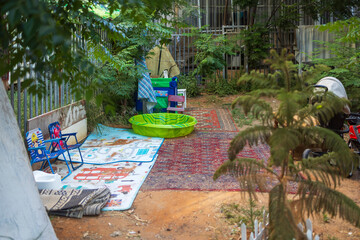 Petah Tikva, Israel, 12 June 2025, Assortment of Objects Next to a Fence Outdoors.  A place to relax in an abandoned area behind garages