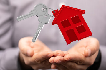 Image of house keys floating above open hands, symbolizing homeownership or real estate.
