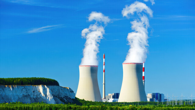 Nuclear power station with cooling towers releasing steam, energy production, nuclear infrastructure, low-carbon electricity generation